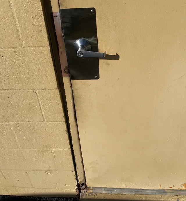 Stainless lever on a black backplate on a cream painted exterior door
