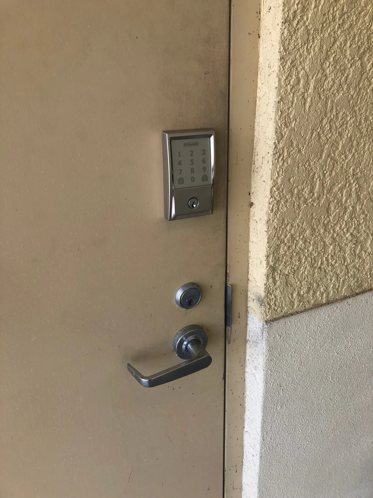 Schlage touchscreen keypad deadbolt above a lever on a steel exterior door