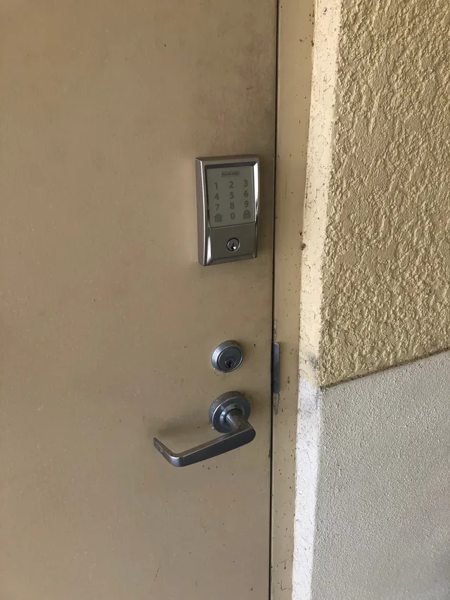 Schlage touchscreen keypad deadbolt above a lever on a steel exterior door